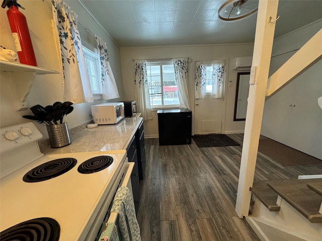 kitchen with a wall unit AC, crown molding, dark wood finished floors, light countertops, and white appliances