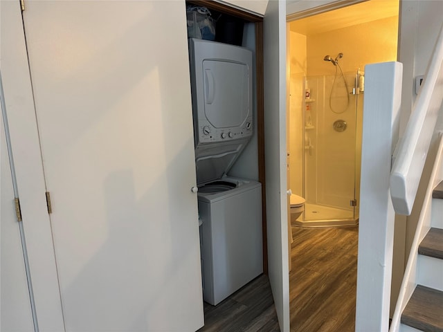 clothes washing area featuring dark wood-type flooring and stacked washing maching and dryer