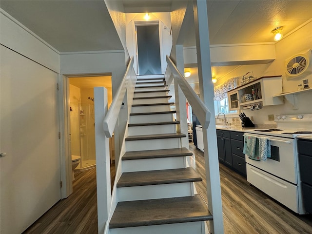 staircase featuring ornamental molding and wood finished floors