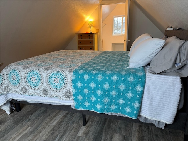 bedroom featuring lofted ceiling and wood finished floors