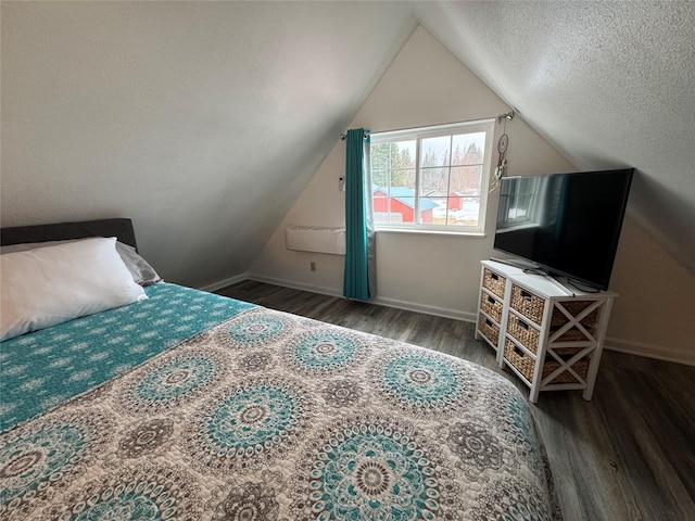 bedroom with vaulted ceiling, a textured ceiling, baseboards, and wood finished floors