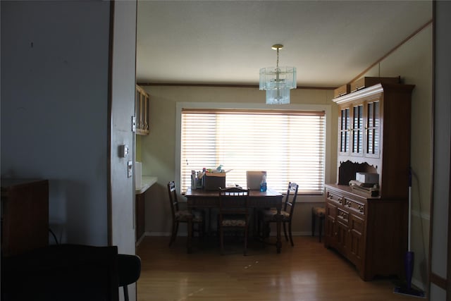 dining room featuring a notable chandelier, baseboards, and light wood-style floors