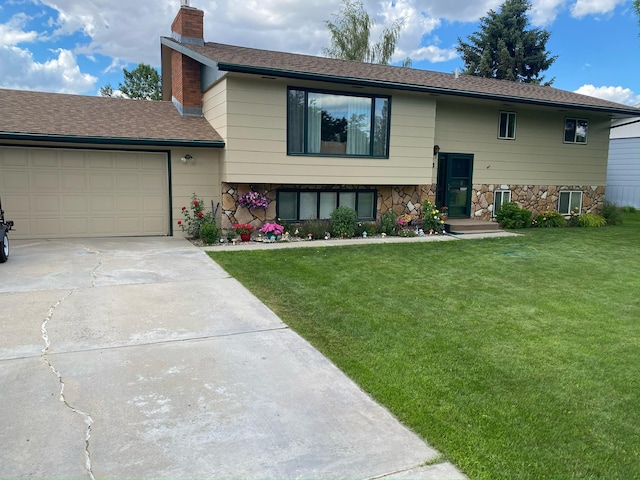 split foyer home with driveway, stone siding, a chimney, and a front yard