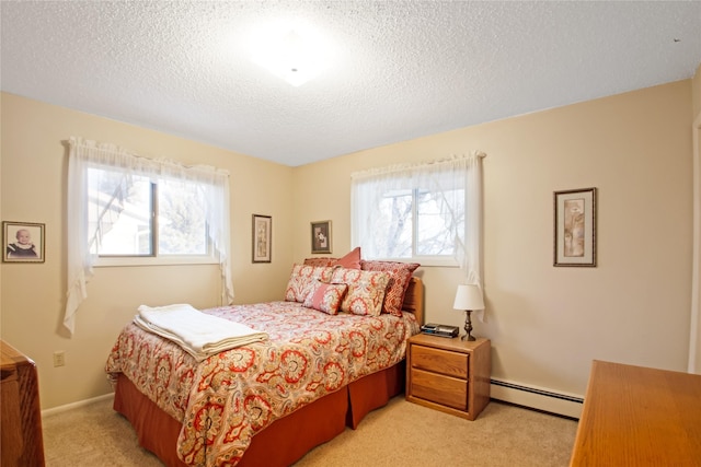 bedroom with light carpet, a textured ceiling, and baseboard heating