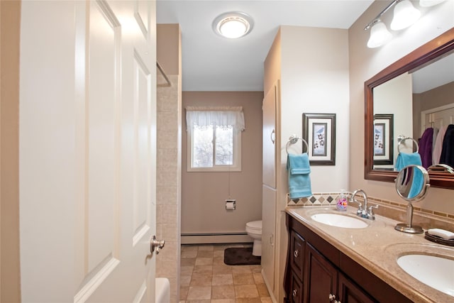 bathroom featuring a baseboard heating unit, a sink, toilet, and double vanity