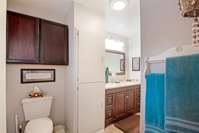 full bath with a sink, toilet, and double vanity