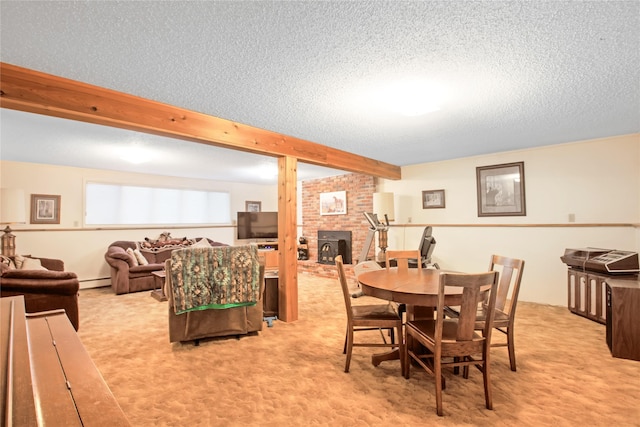 dining area with a baseboard heating unit, beam ceiling, light colored carpet, and a textured ceiling