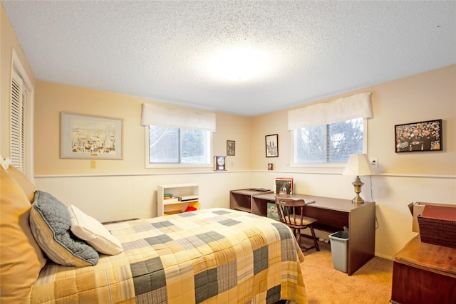 bedroom featuring a closet, a textured ceiling, and light colored carpet