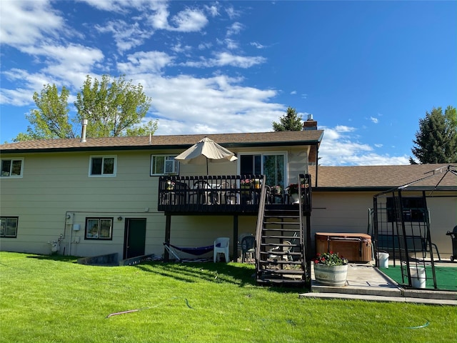 back of house featuring a hot tub, a chimney, stairway, and a yard