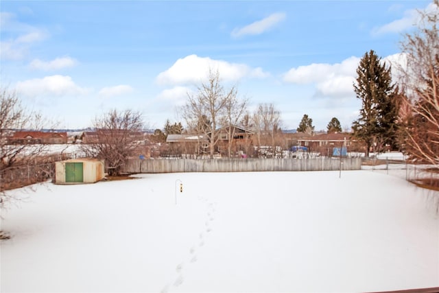 snowy yard featuring fence