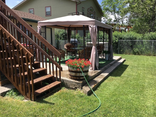 view of play area featuring a gazebo, stairway, fence, and a lawn