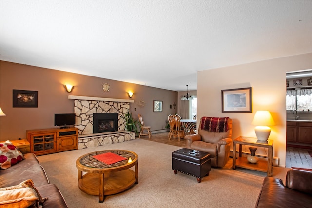 living area with a fireplace, carpet flooring, a baseboard radiator, and an inviting chandelier