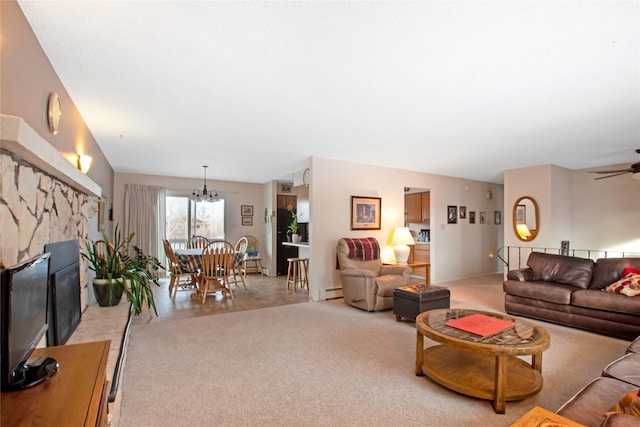 living room featuring light carpet, a fireplace, baseboard heating, and ceiling fan with notable chandelier