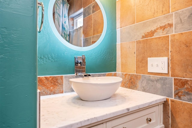 bathroom with a textured wall and vanity