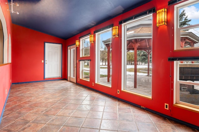 entryway with lofted ceiling, plenty of natural light, and tile patterned floors