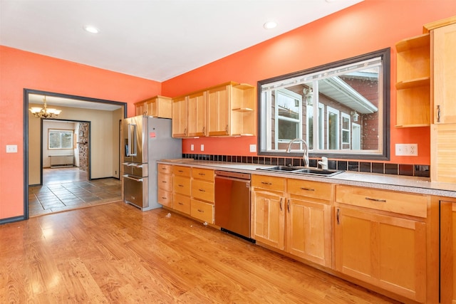 kitchen featuring light wood-style flooring, a sink, light countertops, appliances with stainless steel finishes, and open shelves