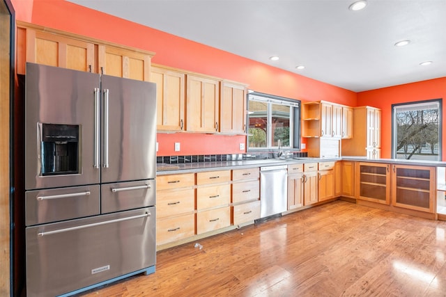 kitchen featuring stainless steel appliances, open shelves, dark countertops, and light brown cabinets