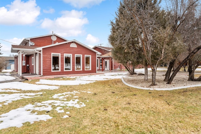 rear view of property with a lawn