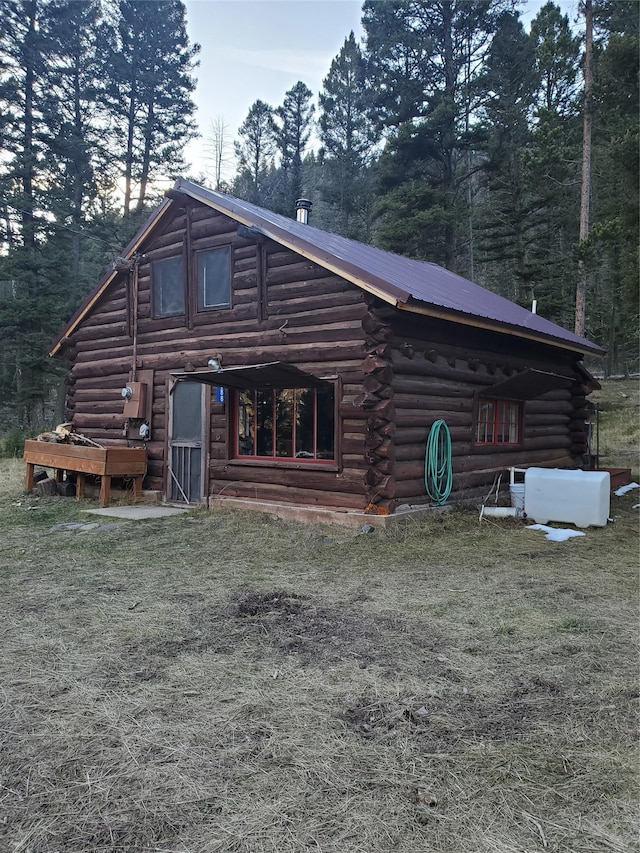 rear view of house with metal roof and log exterior