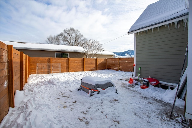 yard layered in snow with a fenced backyard