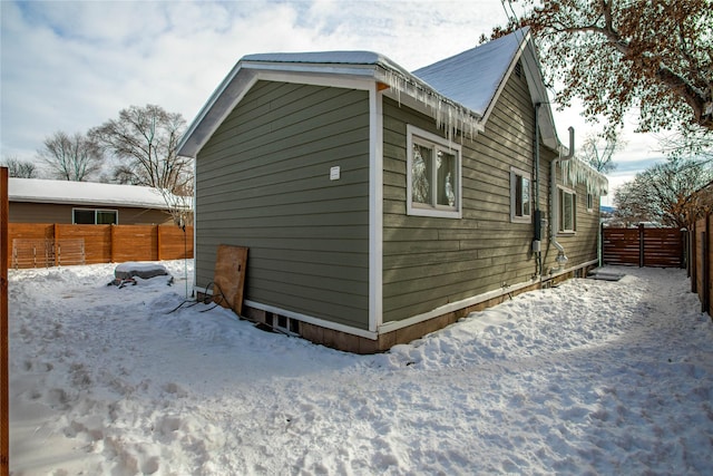 snow covered property with a fenced backyard