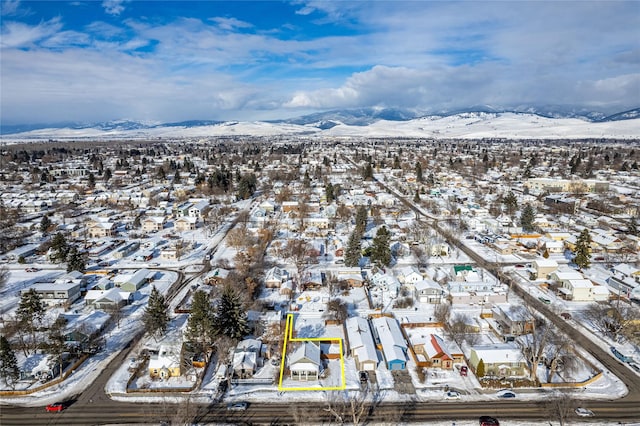 snowy aerial view featuring a mountain view and a residential view