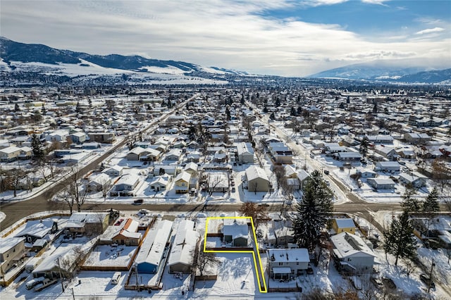 snowy aerial view with a residential view and a mountain view