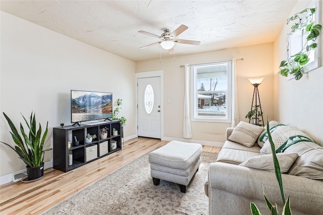 living area with ceiling fan, baseboards, and wood finished floors