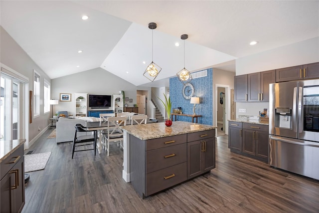 kitchen featuring dark wood finished floors, open floor plan, vaulted ceiling, dark brown cabinetry, and stainless steel fridge