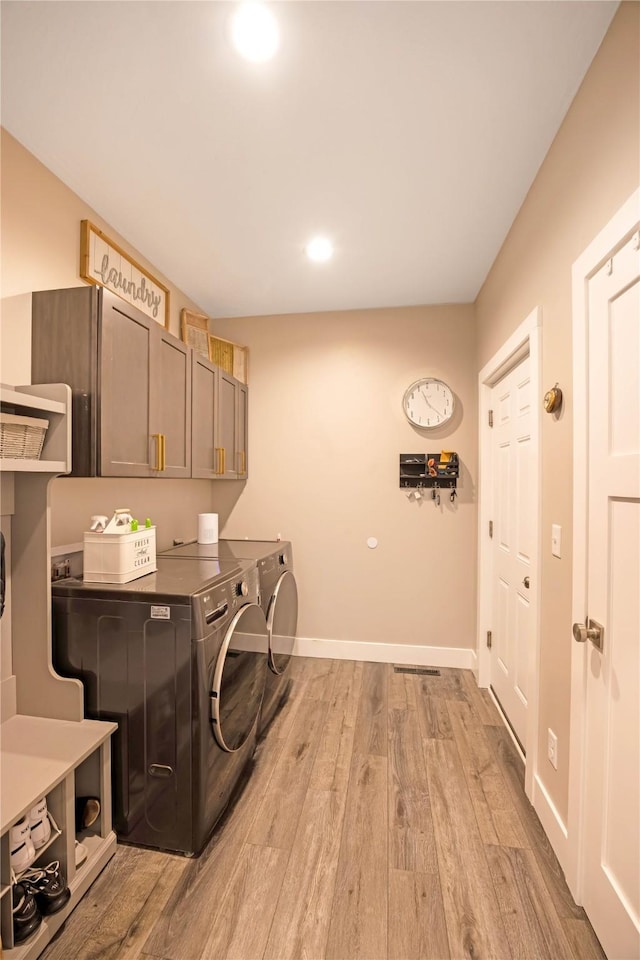 washroom with recessed lighting, cabinet space, light wood-style flooring, washer and dryer, and baseboards