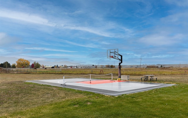 view of basketball court with community basketball court, fence, and a yard