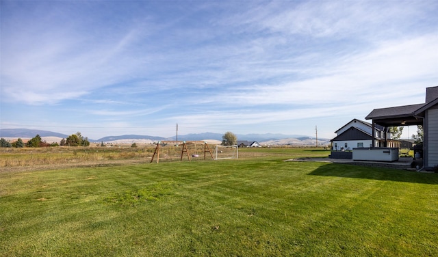 view of yard featuring a rural view, a mountain view, and a hot tub