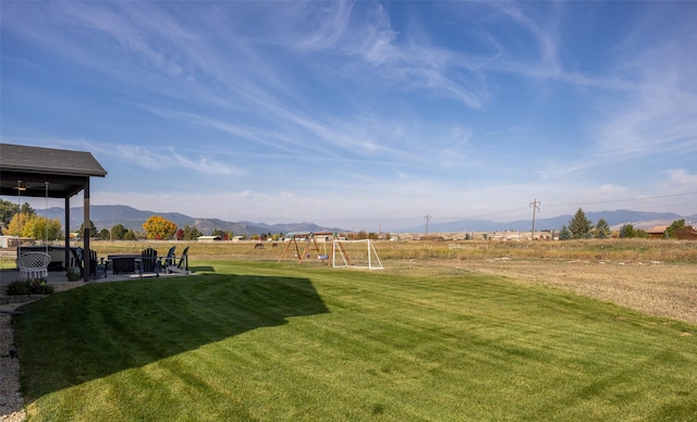 view of yard with playground community, a patio, and a mountain view