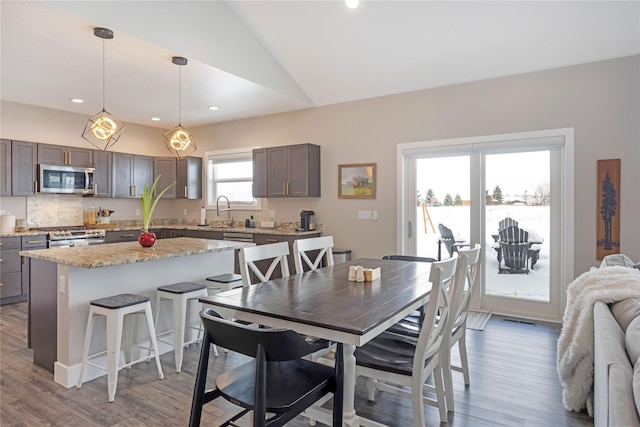 dining area with visible vents, vaulted ceiling, wood finished floors, and recessed lighting