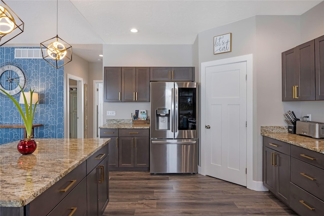 kitchen featuring light stone counters, dark wood finished floors, visible vents, and stainless steel fridge with ice dispenser