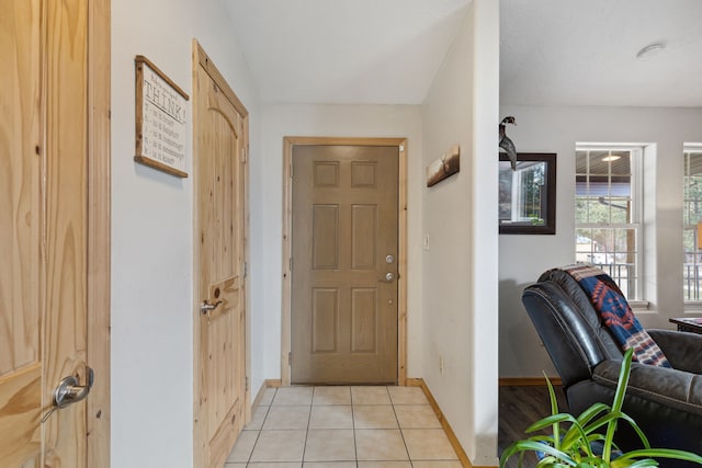 entrance foyer with light tile patterned floors and baseboards