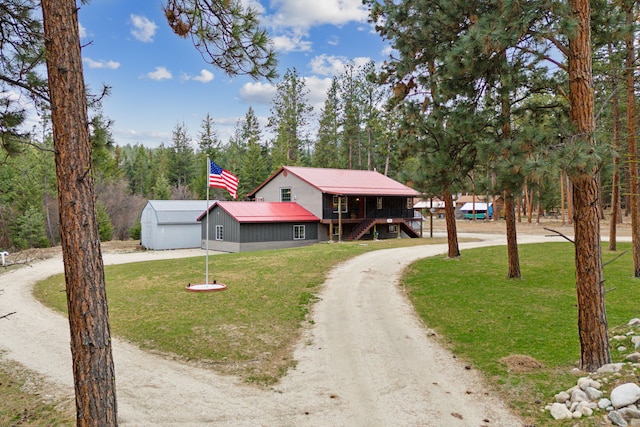 chalet / cabin with dirt driveway, a front lawn, and stairs