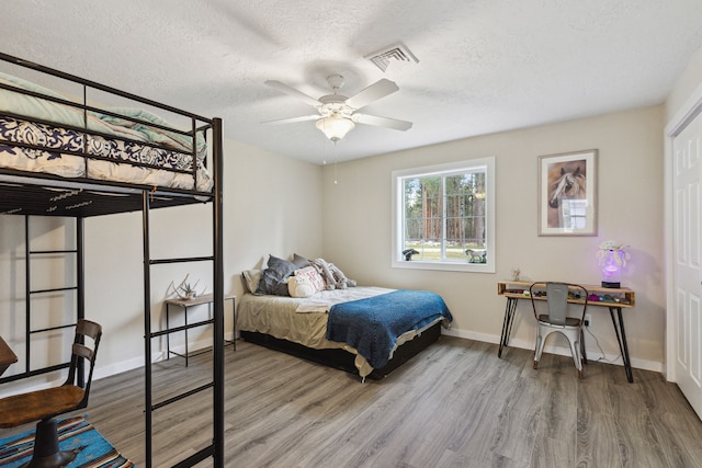 1743 Nighthawk Trl, Victor, MT 59875 - bedroom featuring wood finished floors, a textured ceiling, baseboards, and ceiling fan