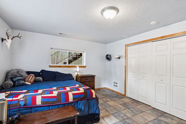 1743 Nighthawk Trl, Victor, MT 59875 - bedroom with baseboards, a closet, stone finish floors, and a textured ceiling