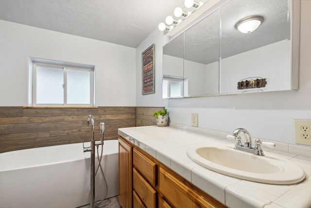 1743 Nighthawk Trl, Victor, MT 59875 - bathroom featuring vanity, a soaking tub, a wainscoted wall, and a textured ceiling