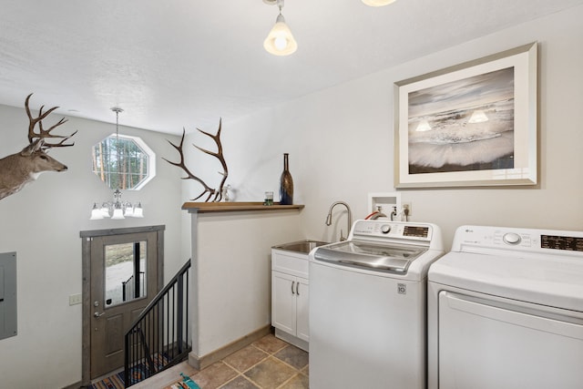 washroom featuring cabinet space, a sink, electric panel, independent washer and dryer, and baseboards