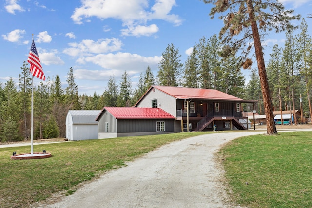 view of front of house with dirt driveway, a porch, stairway, metal roof, and a front lawn