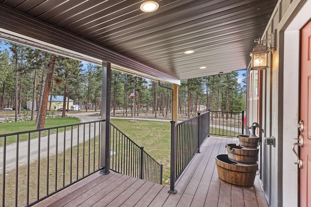 deck featuring covered porch and a lawn