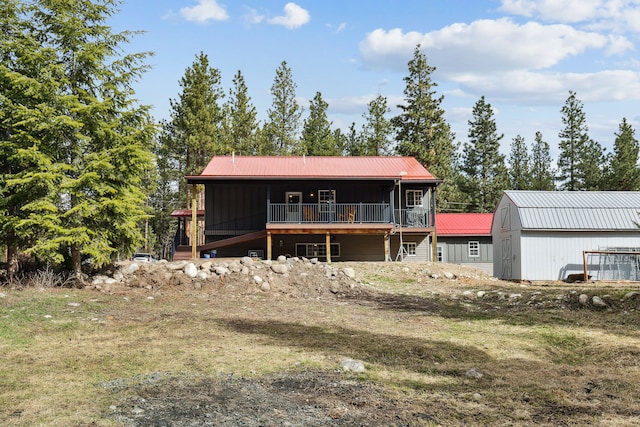 back of property with metal roof and an outbuilding