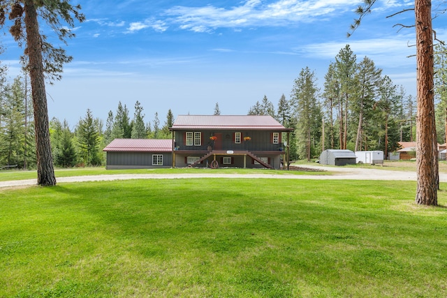 1743 Nighthawk Trl, Victor, MT 59875 - view of front of house featuring stairs, a front yard, metal roof, and curved driveway