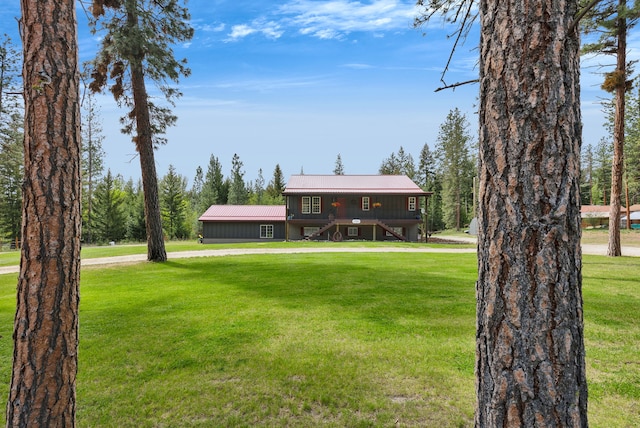 1743 Nighthawk Trl, Victor, MT 59875 - view of front of house featuring stairs, a front yard, metal roof, a deck, and driveway