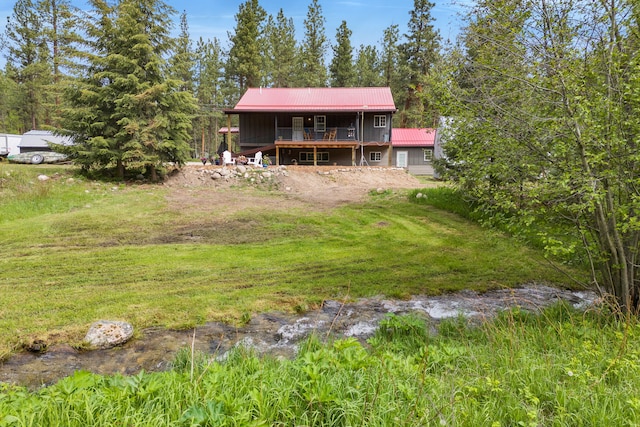 1743 Nighthawk Trl, Victor, MT 59875 - rear view of property featuring metal roof, a deck, and a yard