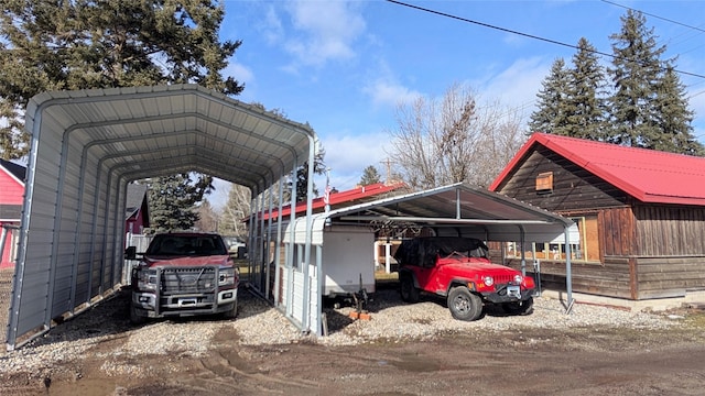 403 Dakota Ave, Libby, MT 59923 - view of parking / parking lot featuring a detached carport and driveway