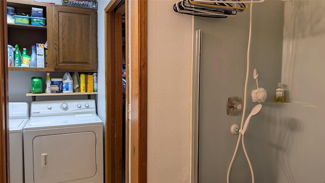 washroom featuring independent washer and dryer and cabinet space