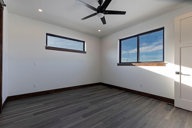 spare room featuring a wealth of natural light, baseboards, and wood finished floors